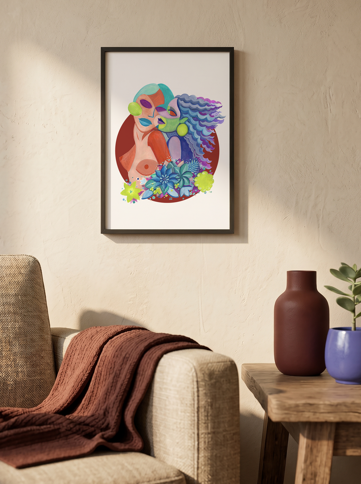 A framed colorful art print featuring a stylized face with vibrant blue, green, and red details, hanging on a textured beige wall above a beige armchair with a brown throw blanket, next to a wooden side table with two vases and a small plant.