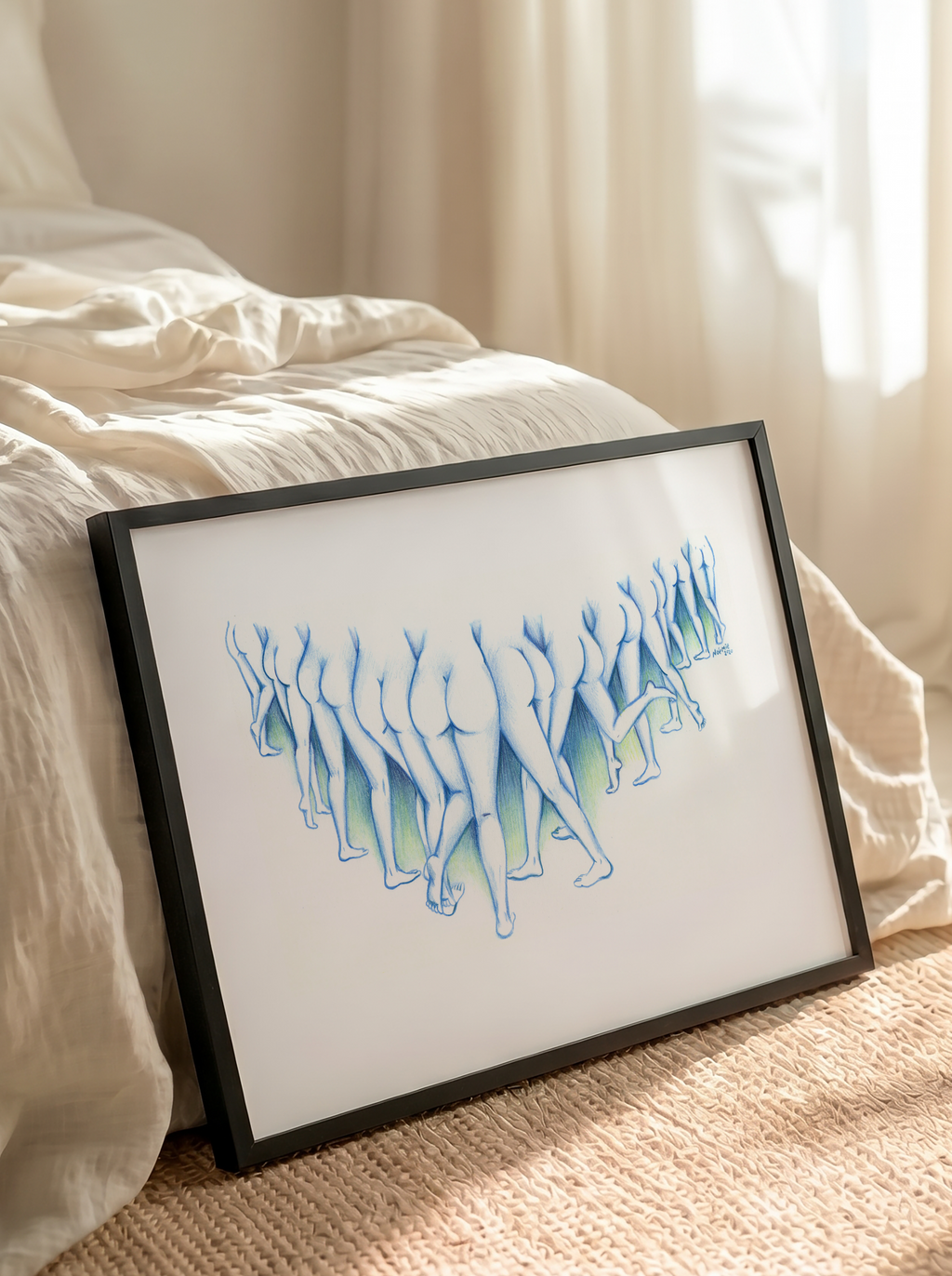 A framed art print featuring a stylized blue and green line drawing of figures, leaning against a bed in a softly lit bedroom with beige curtains and a woven rug.