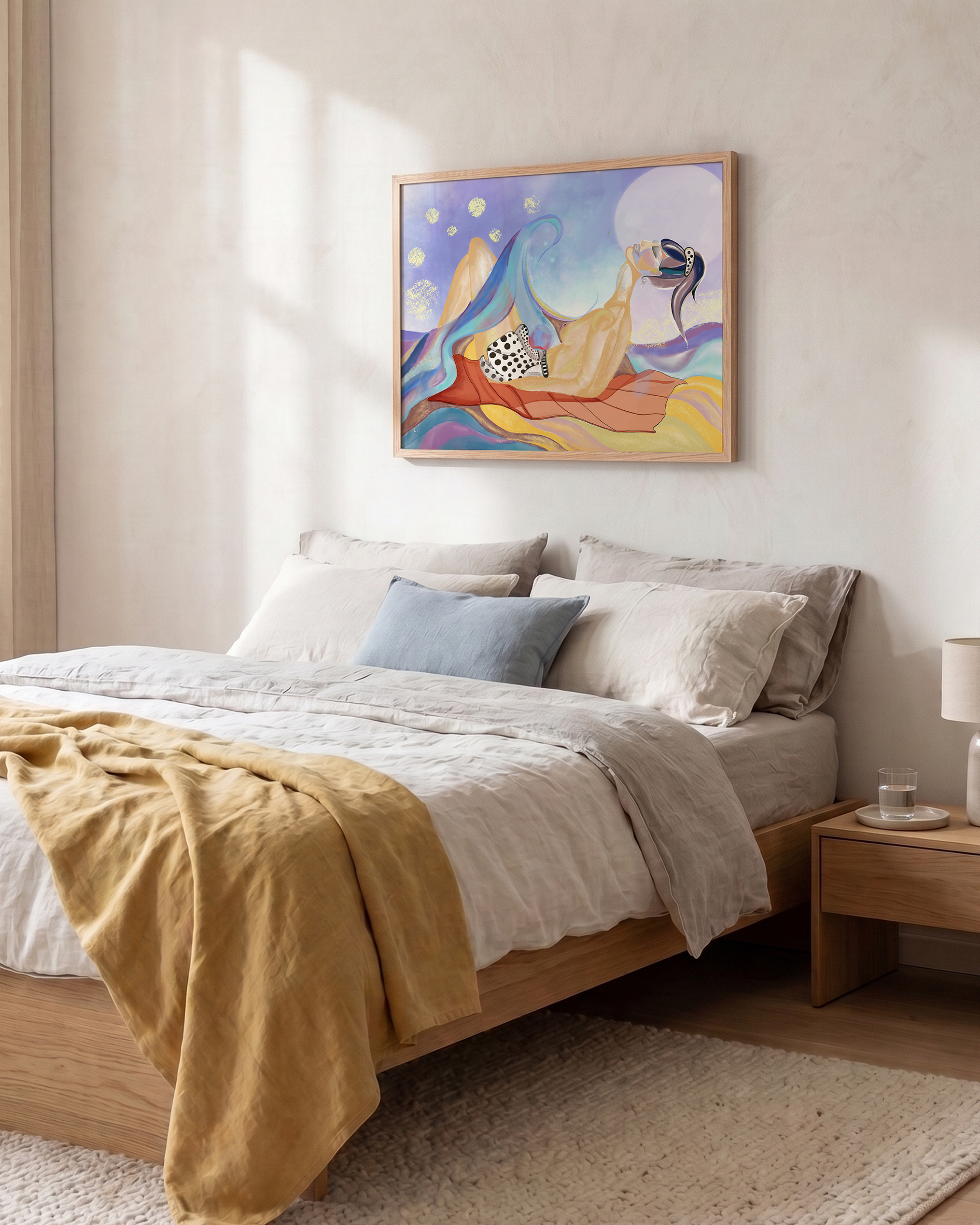 A colorful framed abstract art print hangs on a textured off-white wall above a neatly made bed with beige linens, a mustard yellow throw blanket, and a light blue accent pillow in a bright, modern bedroom.